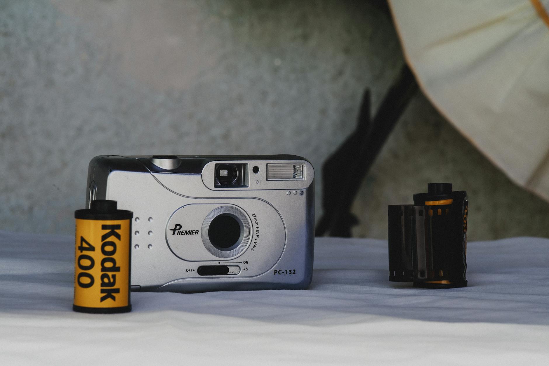 Retro Premier PC-132 camera and Kodak film rolls, showcasing classic photography tools.