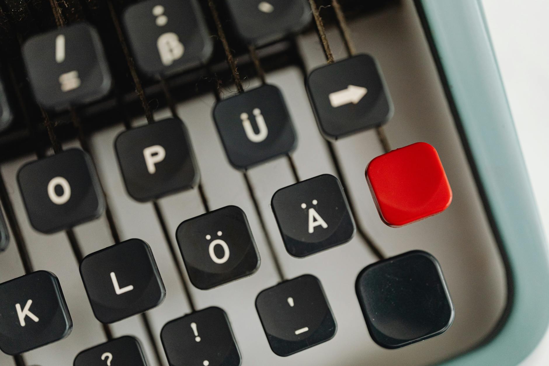 Detailed close-up of vintage typewriter keys with unique characters and a distinct red key.