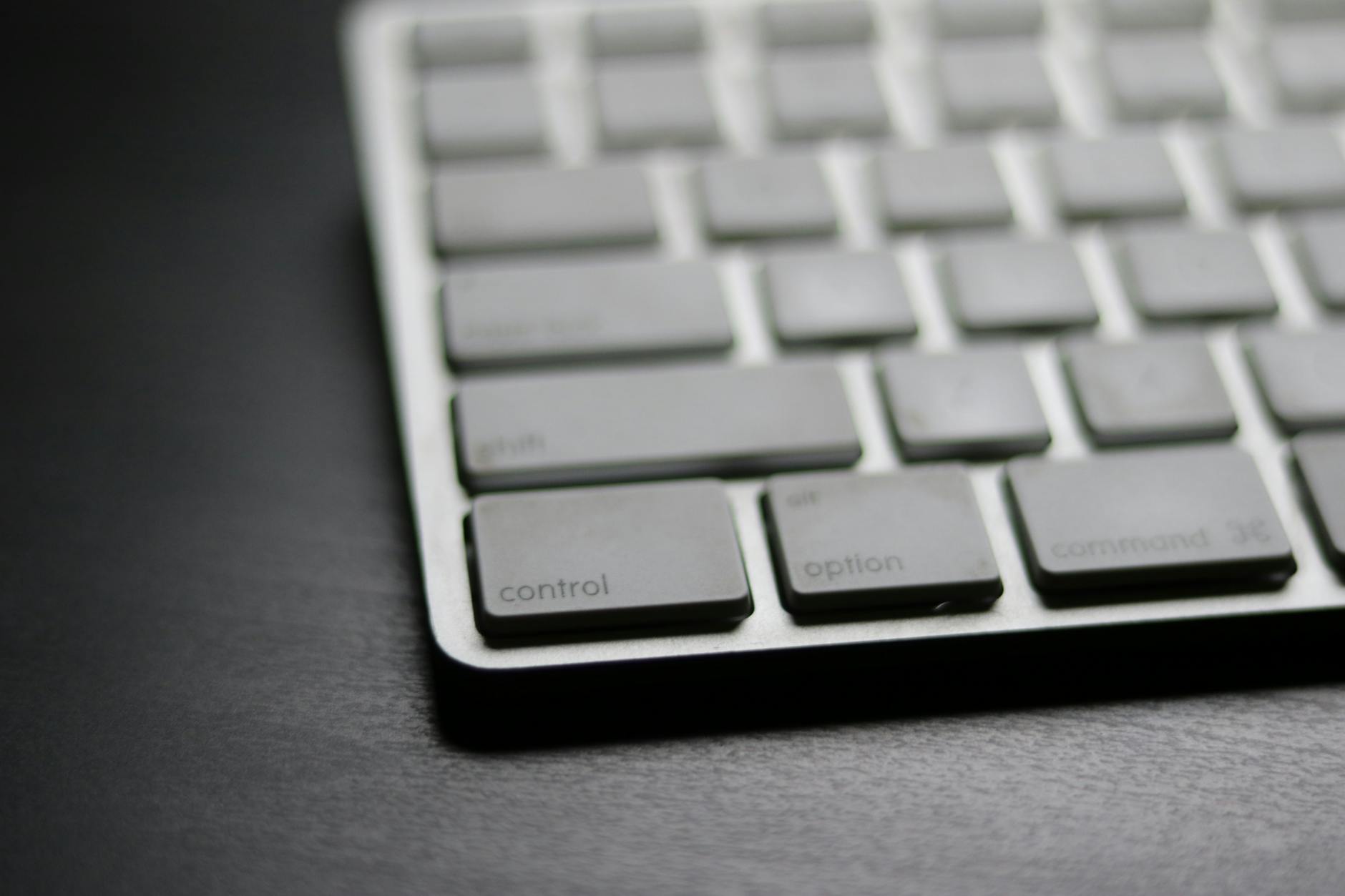 Detailed close-up of a sleek modern wireless keyboard on a dark surface.